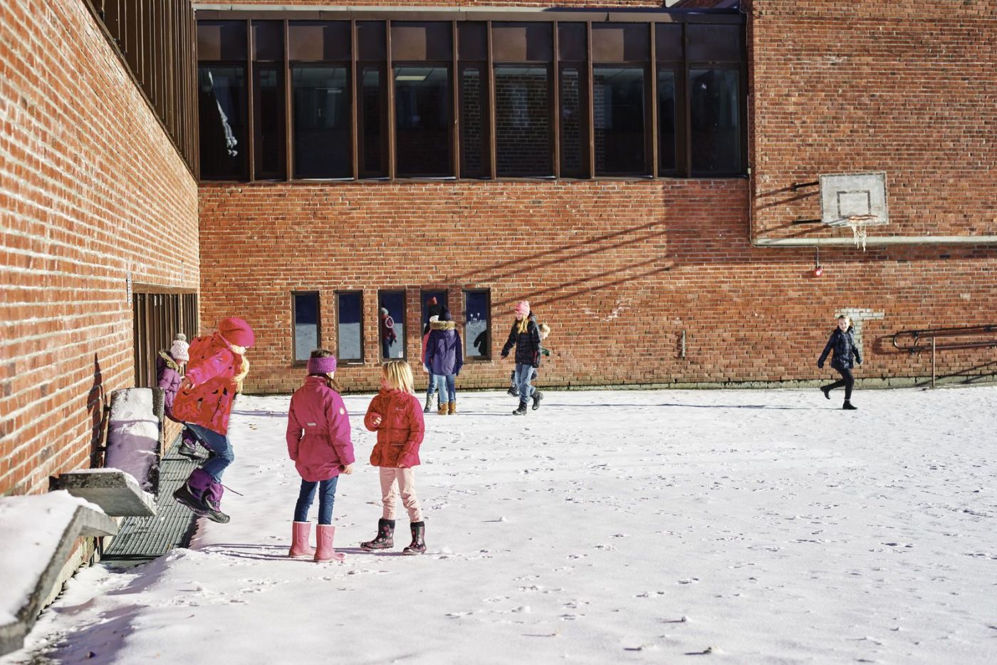 Elever leker i en snøkledd skolegård. Foto: Øivind Haug
