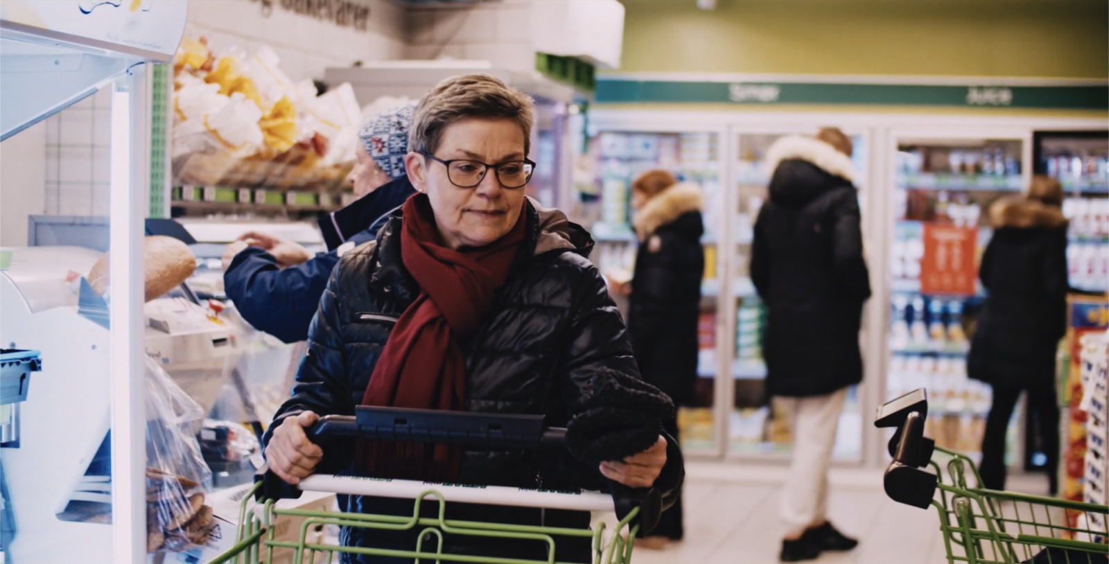 Dame med handlevogn på butikken.