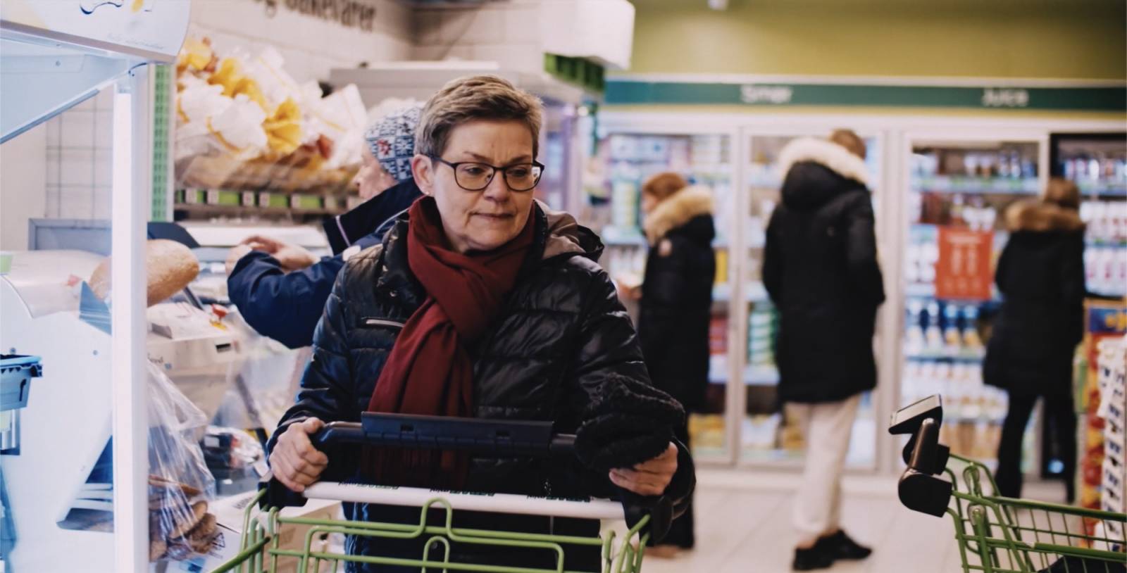 Dame med handlevogn på butikken.