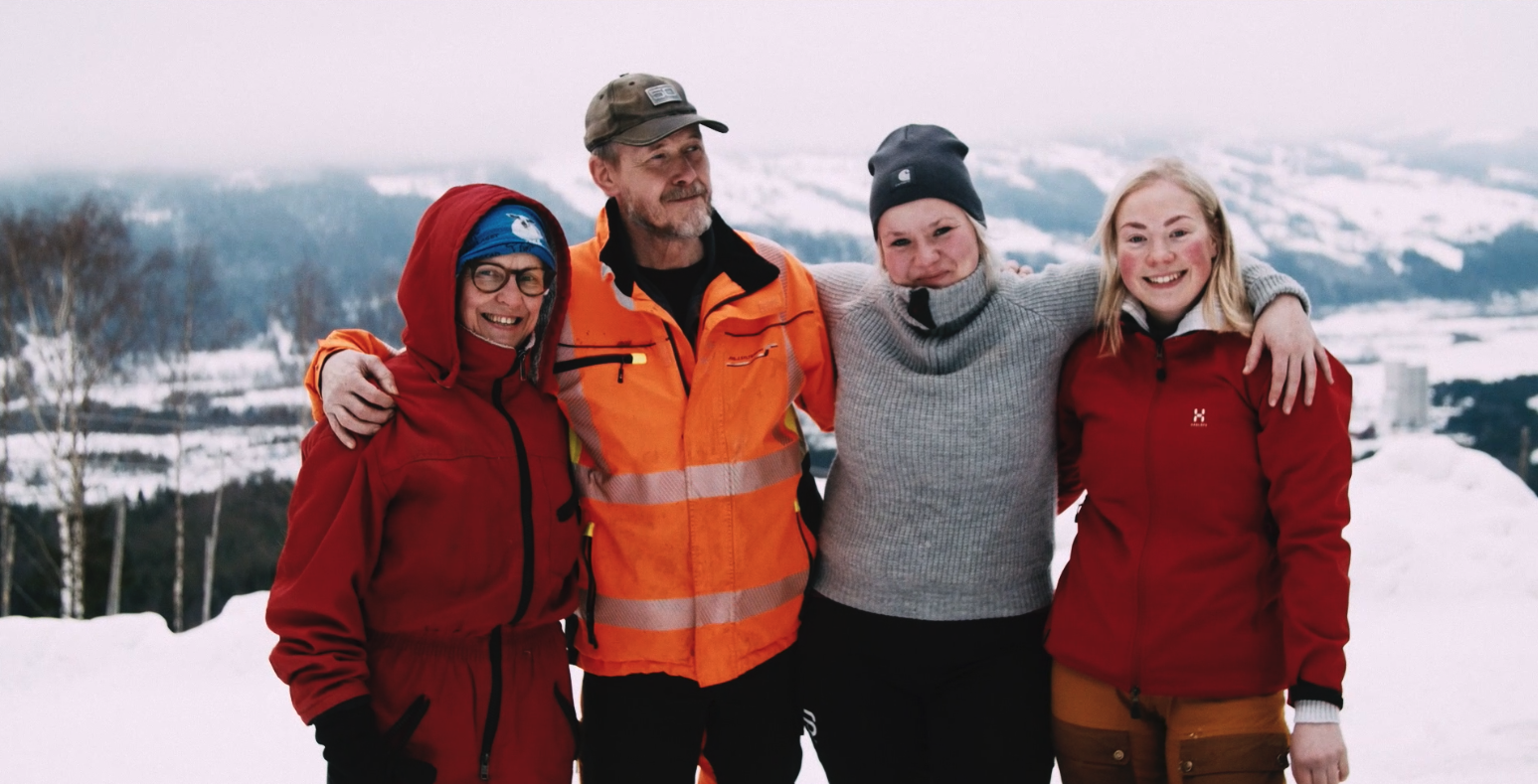 Fire mennesker i familie, som holder rundt hverandre.