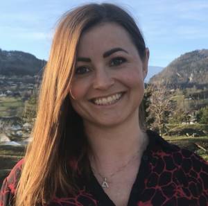 Henny Kristin- rett framanfrå, smilande i kamera.