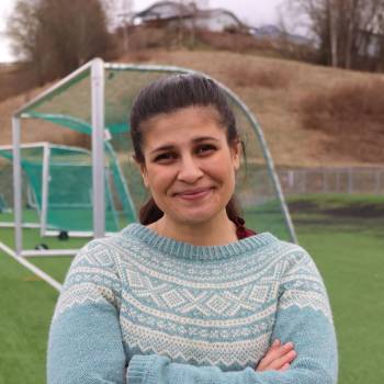 Hoda Imad står på en fotballbane foran et fotballmål