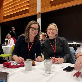 Anne Berit og Åse Kristin med briller smiler til kamera. 