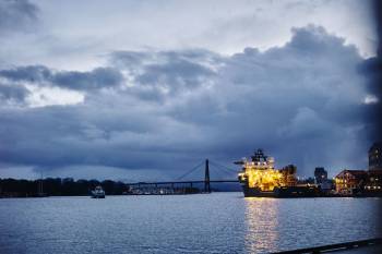 Et opplyst industriskip ligger til kais i en rolig bukt. Foto: Øivind Haug