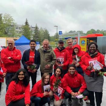 En blid gjeng fra Arbeiderpartiet poserer med roser og flyers