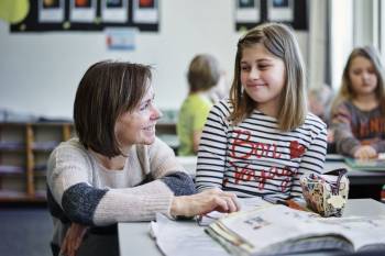 En lærer hjelper en av elevene sine med skoleoppgaver. Foto: Øivind Haug