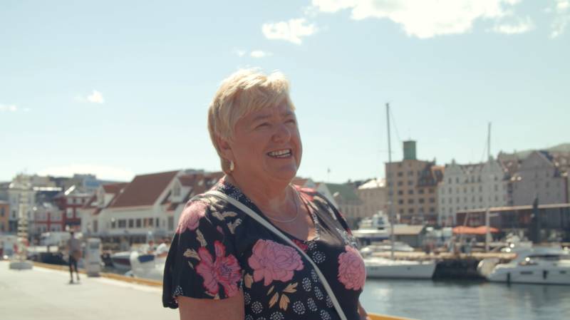 Eldre dame som smiler i fint vær.