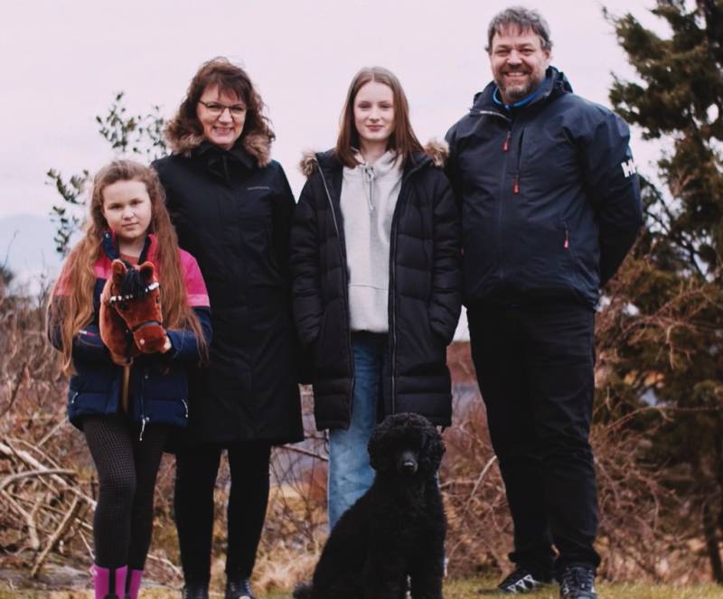 Familie på fire og en hund, utendørs.