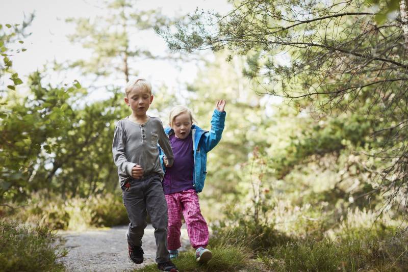 To barn går jublende på en skogssti. Foto: Øivind Haug