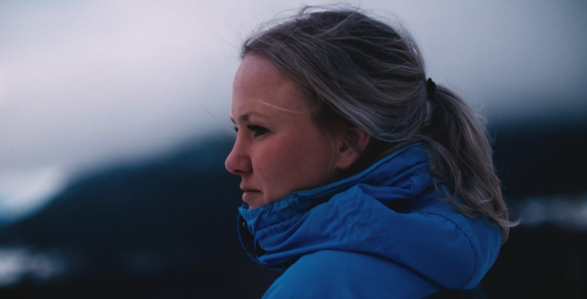Dame som ser utover naturlandskap.