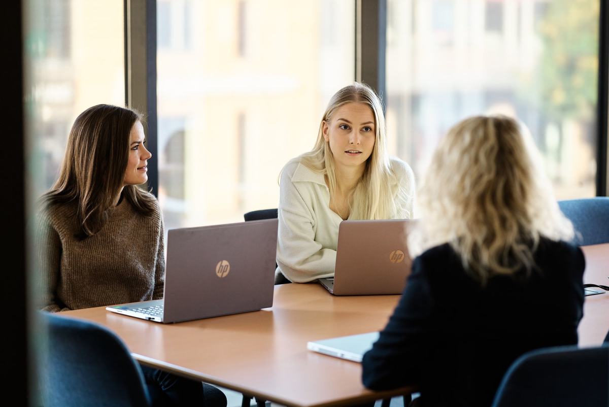 Tre personer på møterom
