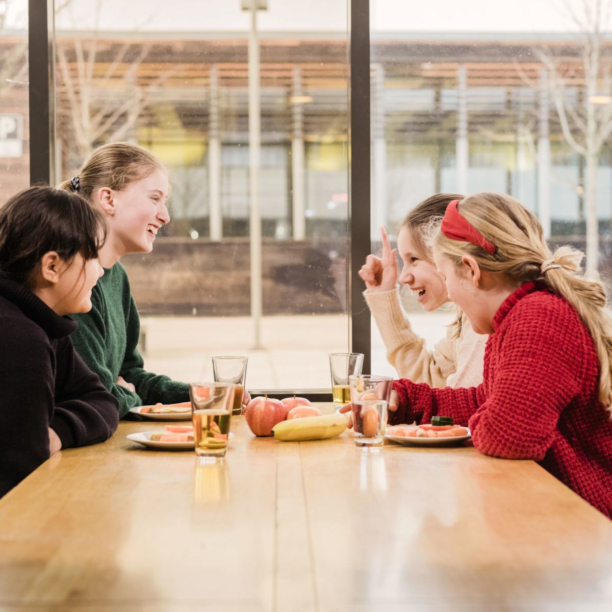 Ungdom som smiler til hverandre under skolelunsj