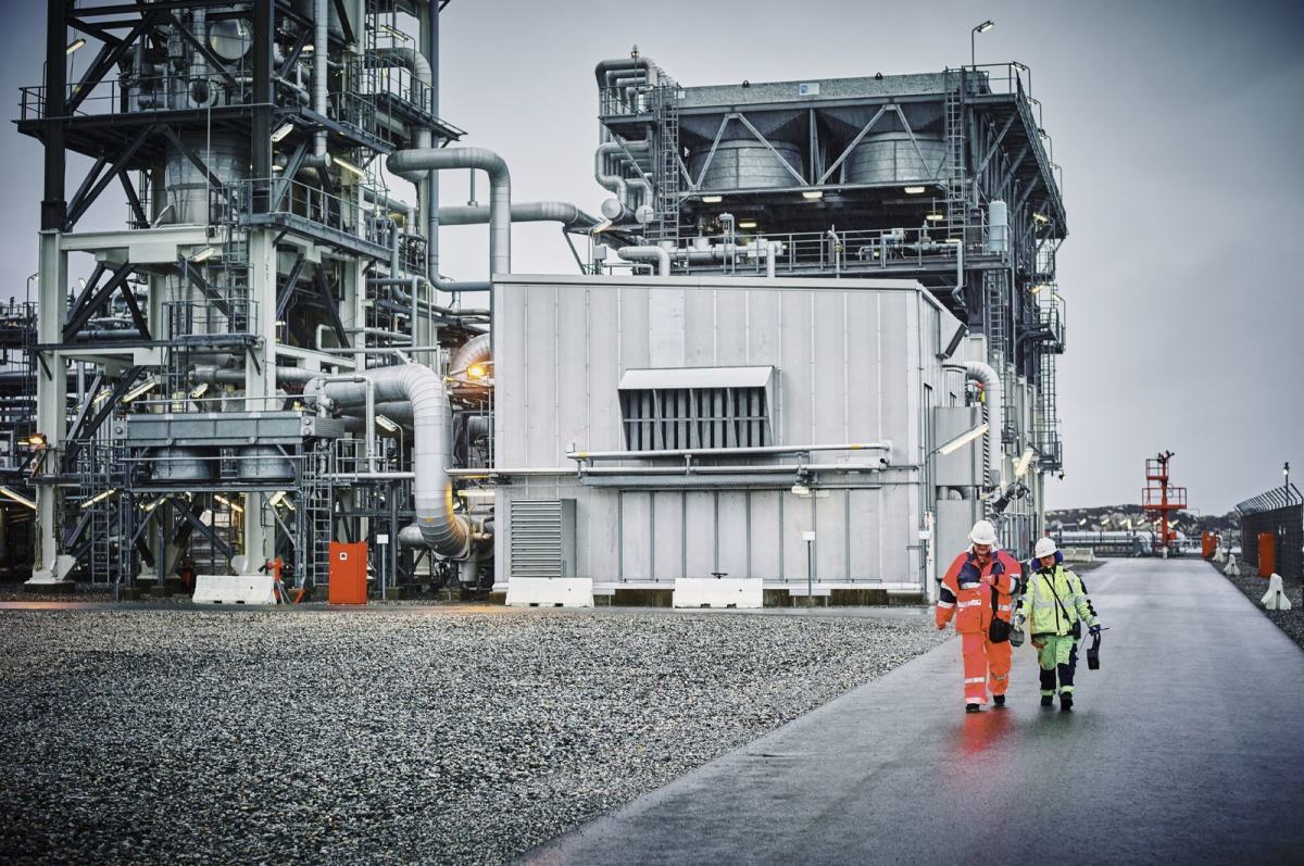 To arbeidere går langs veien ved et industriområde. Foto: Øivind Haug