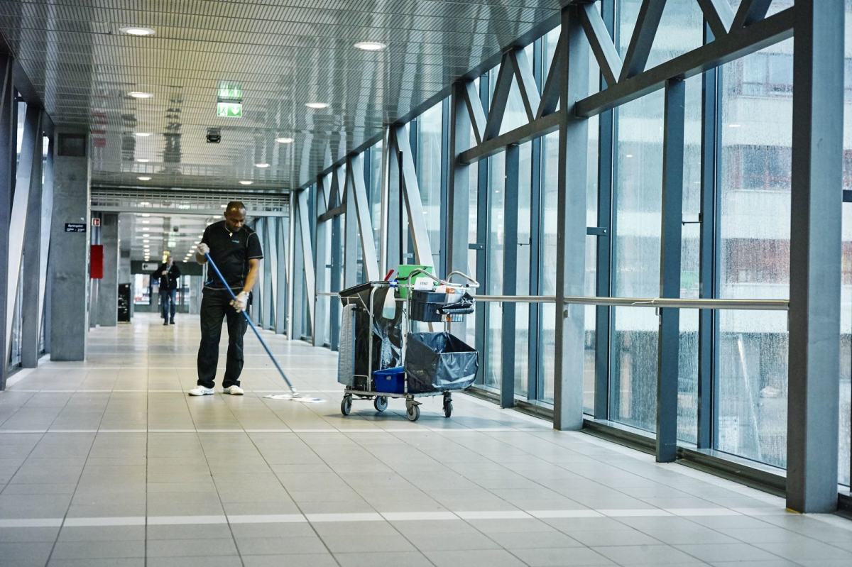 En renholdsarbeider står og vasker en gang. Foto: Øivind Haug