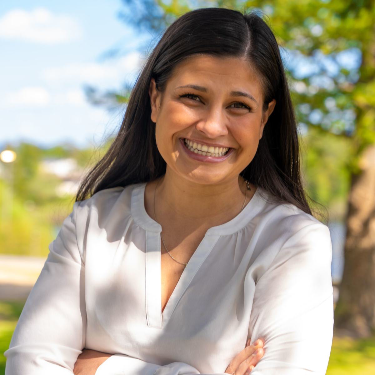 Hoda står med hendene i kryss og smiler 