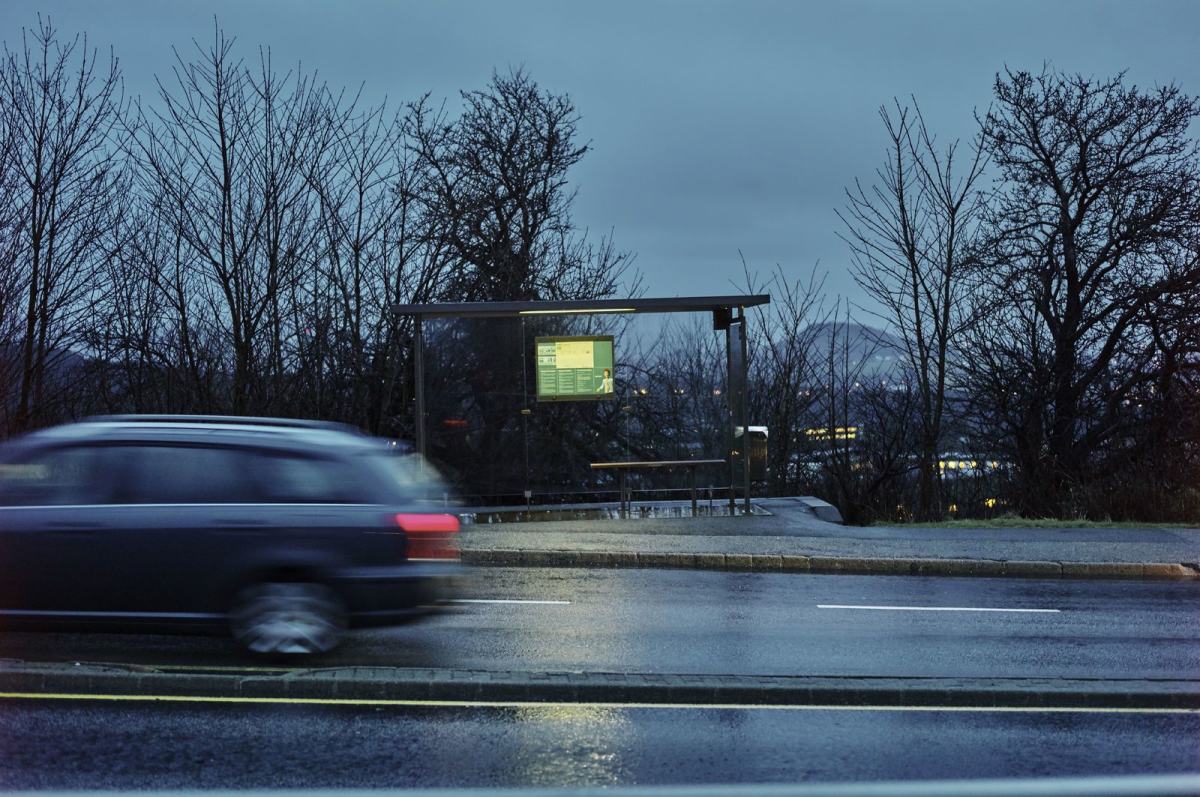 Bil kjører forbi et busstopp i distriktsnorge. Foto: Øivind Haug