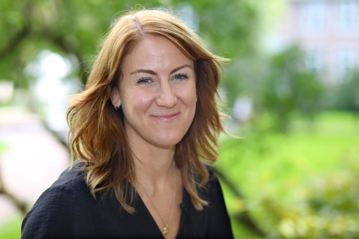 Smilende dame med svart kjole og gullkjede