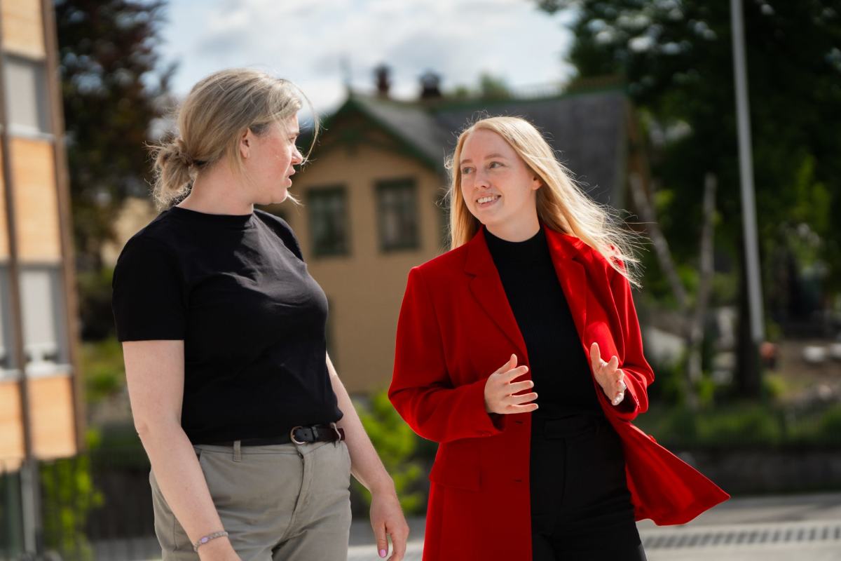 Ordførerkandidaten på Voss går og snakker med en ansatt i heradet. 