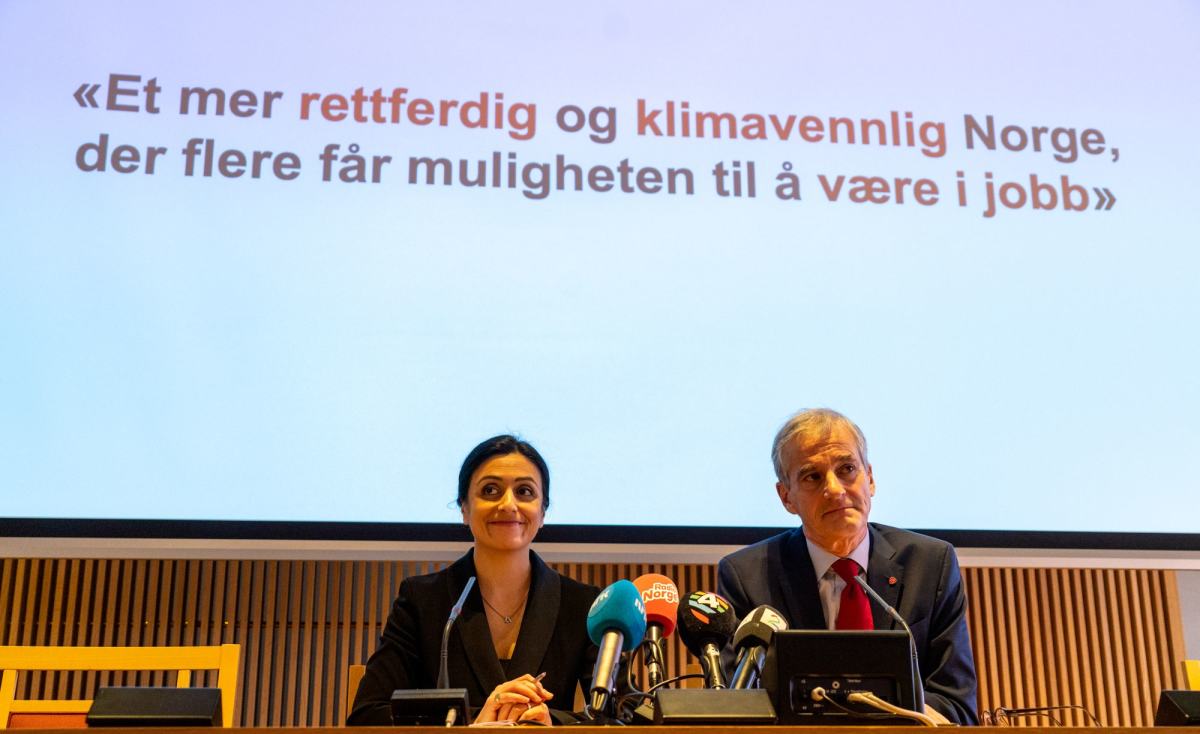 Hadia Tajik og Jonas Gahr Støre sitter foran en skjerm med teksten "Et mer rettferdig og klimavennlig Norge, der flere får muligheten til å være i jobb".