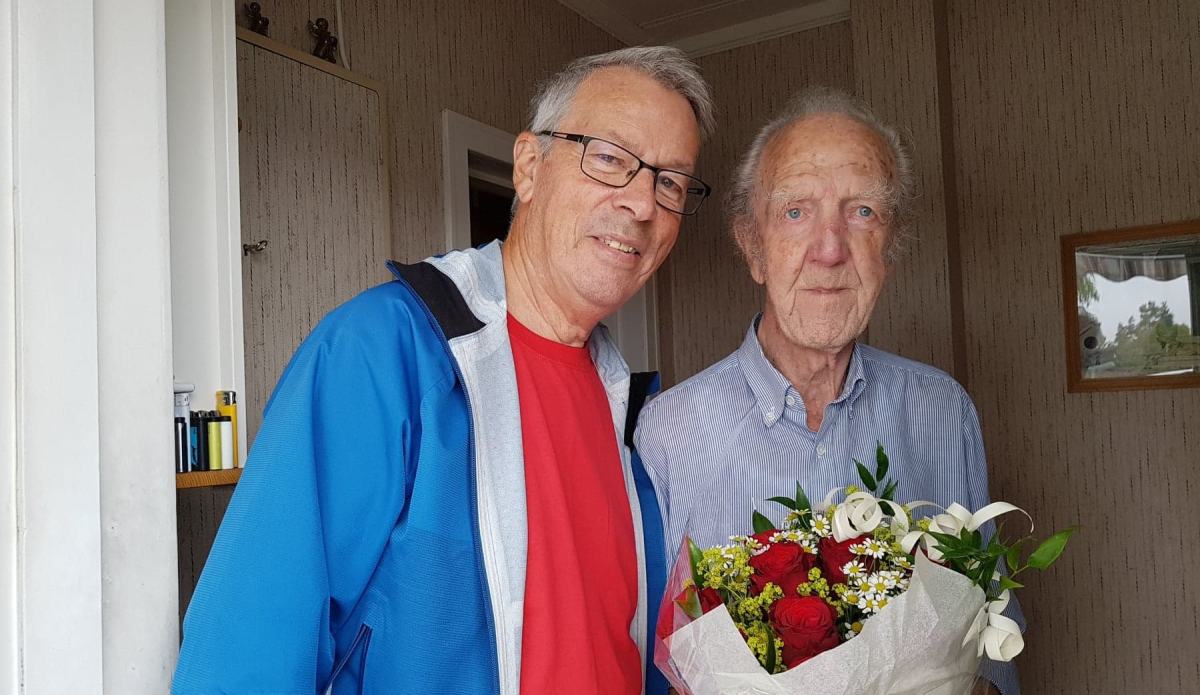 Tore Wollum overrekker blomster til Arne Lund, 85 år