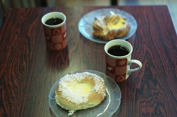 Kaffepause med kaffe og bakverk på et mørkt bord. Foto: Øivind Haug