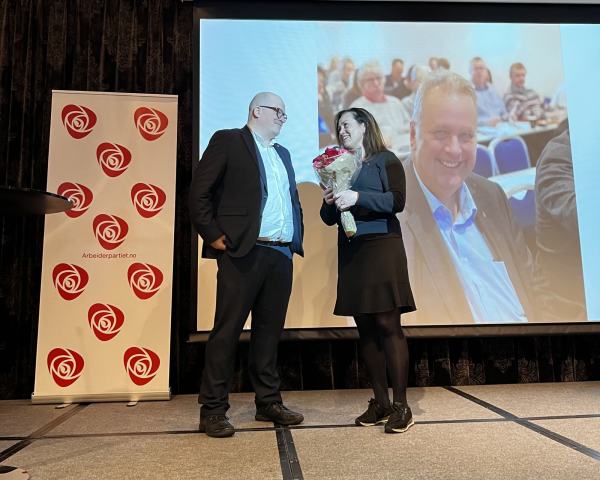 Per Vidar og Anne Berit står å ser på hverandre. Anne Berit har fått en buket røde roser
