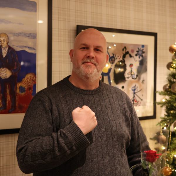 Vidar Schei portrett stående foran en vegg med juletre