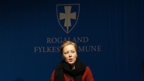 Fylkesvaraordfører Marianne Chesak på talerstolen foran Rogaland Fylkeskommune sin logo.