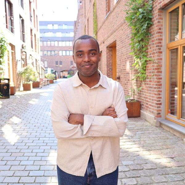 Hashim Abdi smiler med kryssede armer.
