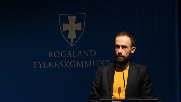 Simon Næsse fra talerstolen foran Rogaland Fylkeskommune sin logo