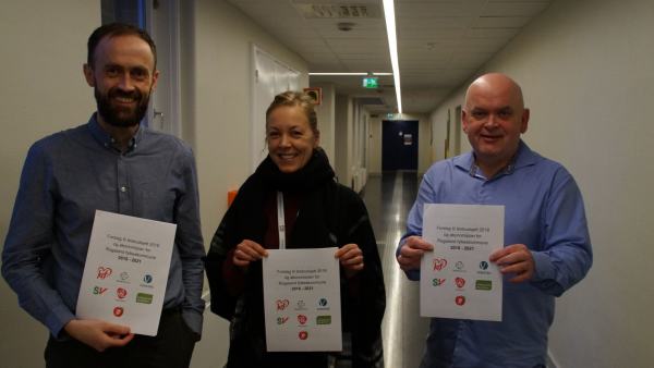 Fra venstre står Simon Næsse, Marianne Chesak og Jarle Nilsen. Alle holder et eksemplar av budsjettforslaget til flertallet.