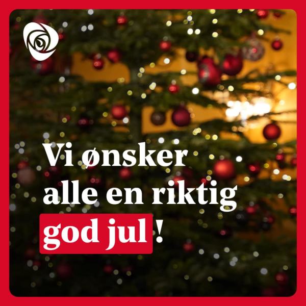 Vi ønsker alle en riktig god jul! plakat, med juletre i bakgrunn. Og Arbeiderparti rose oppe i venstre hjørne.