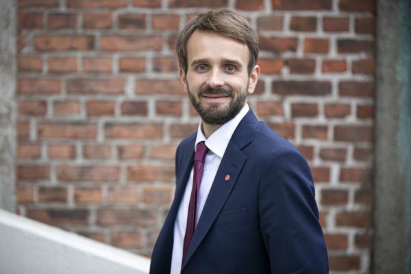 Bildet viser pressebilde av Jan Christian Vestre foran brun mursteinsvegg.
