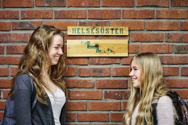 To skolejenter står foran kontorskiltet til helsesøster. Foto: Øivind Haug