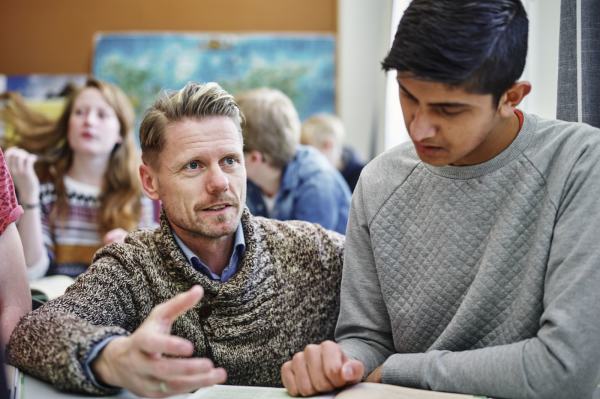 En ungdomsskolelærer hjelper og veileder en av sine elever. Foto: Øivind Haug