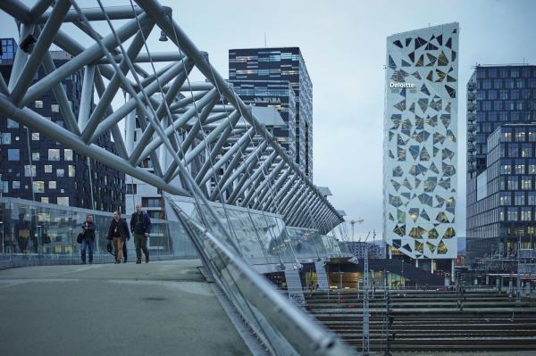 Akrobaten bro strekker seg over togskinnene og mot nybyggene i barcode. Foto: Øivind Haug
