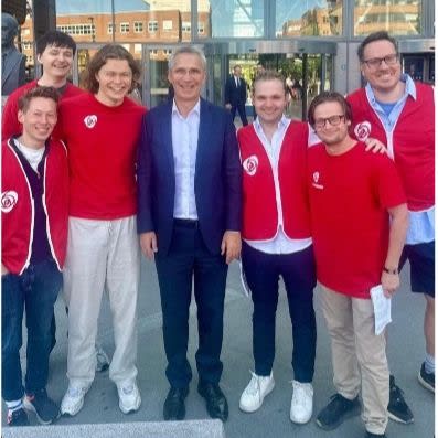 Partikamerater fra Astud Oslo smiler sammen med Jens Stoltenberg etter at han hadde holdt forelesning på BI. Fasaden og inngangspartiet til BI er i bakgrunnen og våre folk fra Astud Oslo har på seg partiklær.