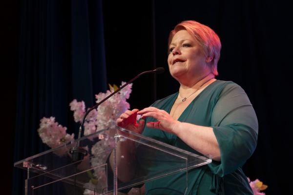 Marthe Scharning Lund i grønn kjole på talerstolen i Samfunnssalen