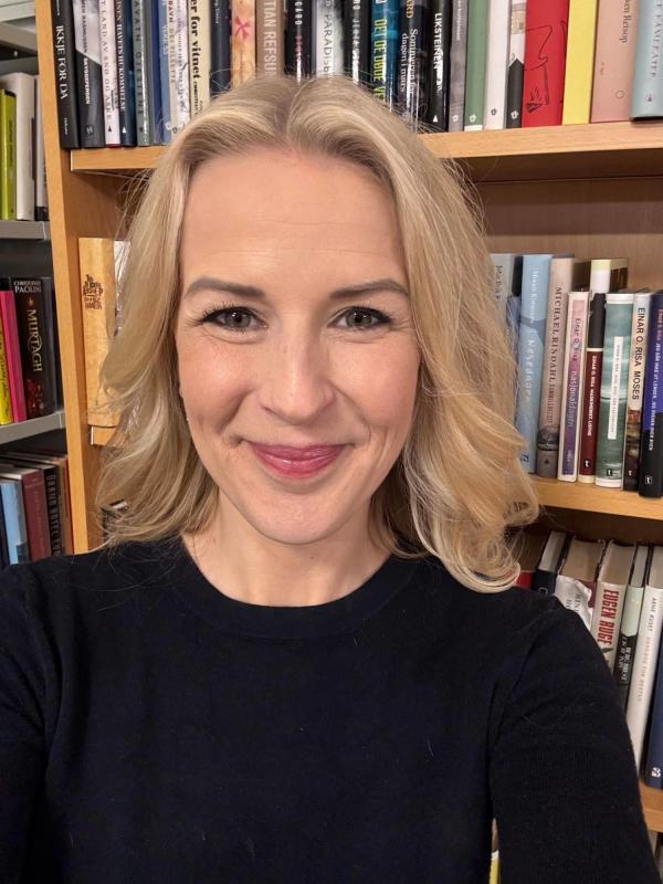 Elise Waagen foran en bokhylle på biblioteket