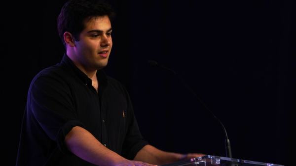 Leder for AUF i Oslo, Eduardo Mezzanotti-Camerini, i sort genser på talerstolen i Samfunnssalen