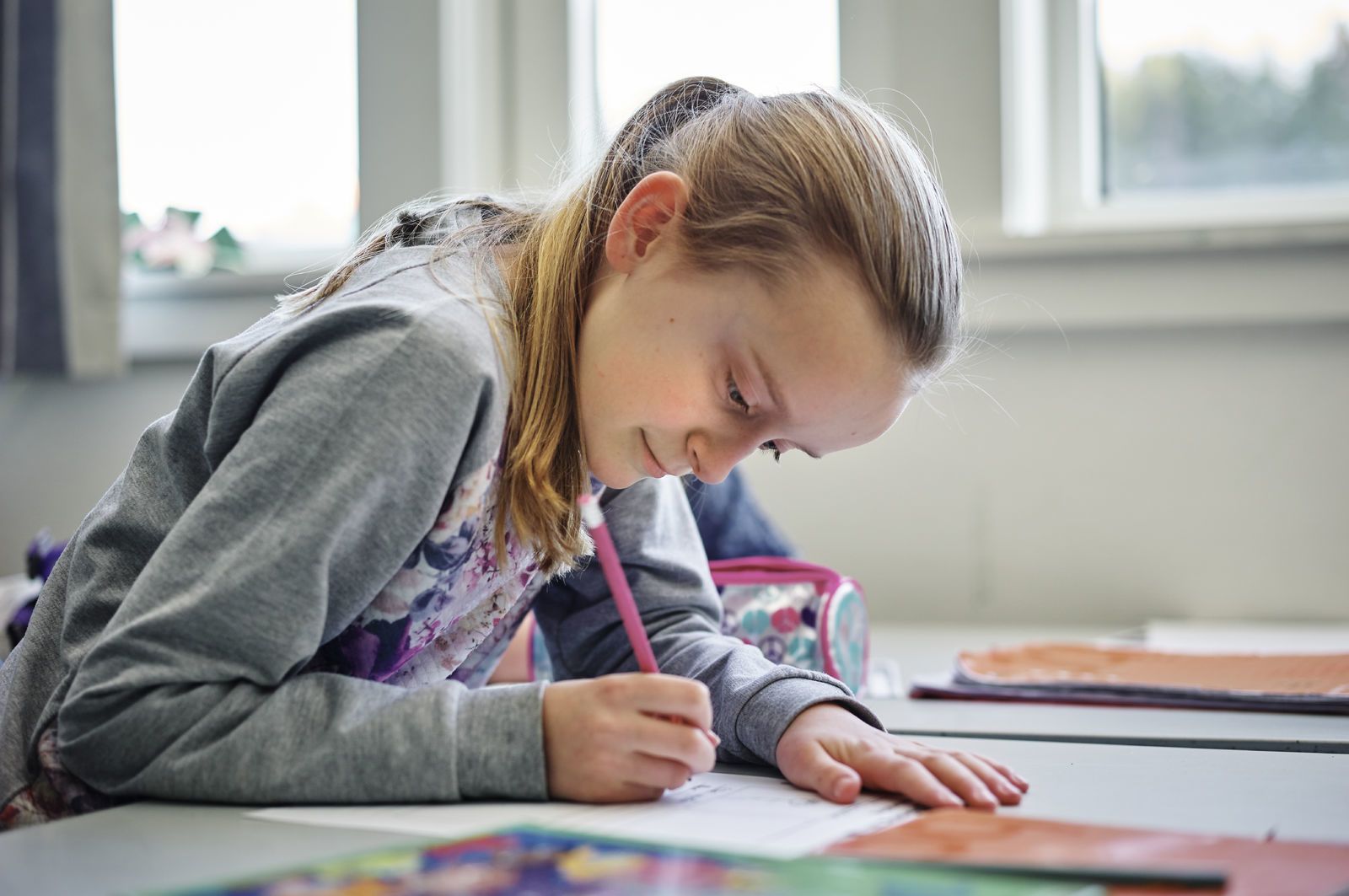 En barneskolejente jobber med skolearbeid. Foto: Øivind Haug