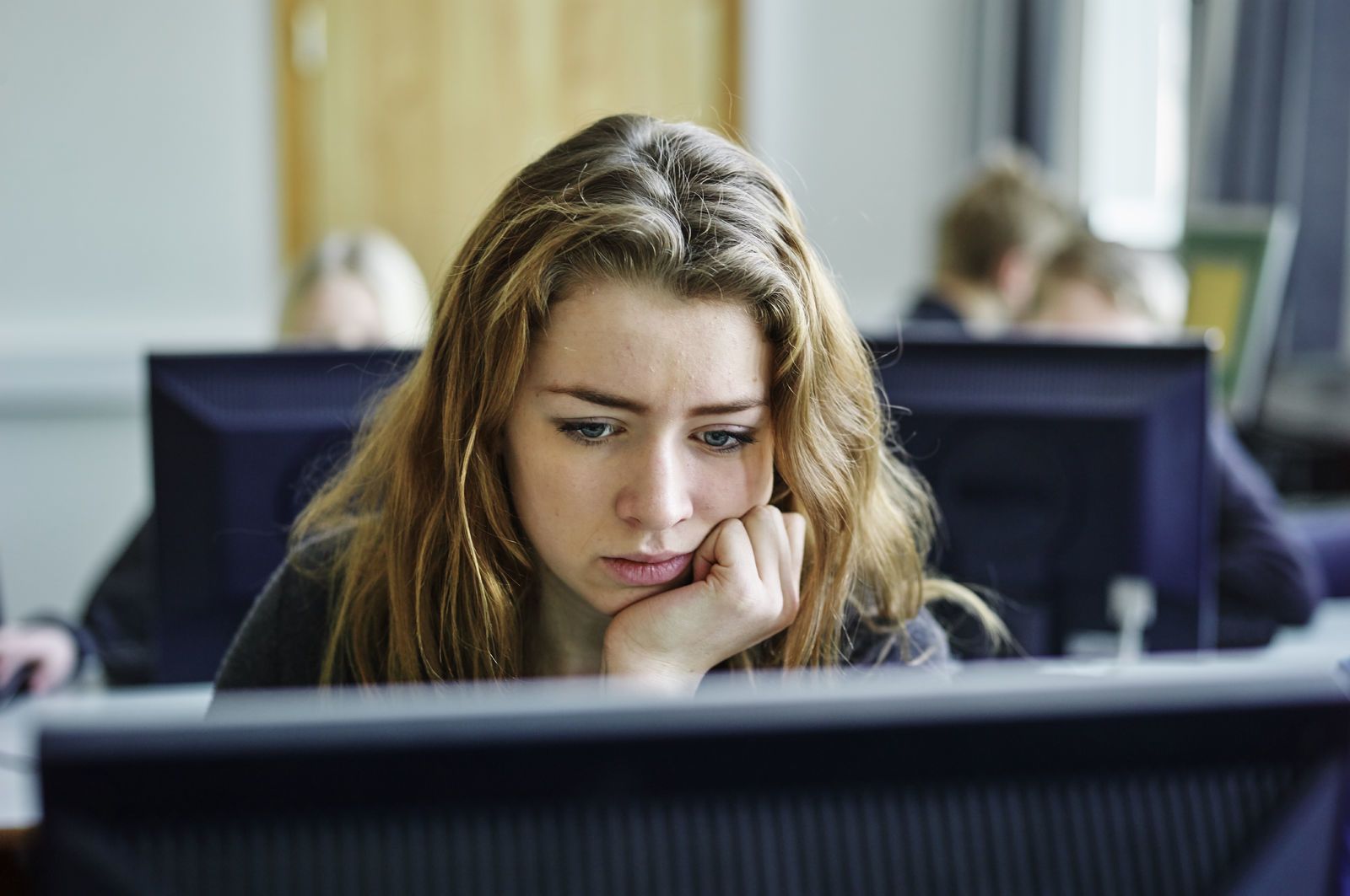 En skolejente sitter og jobber på datamaskin. Foto: Øivind Haug