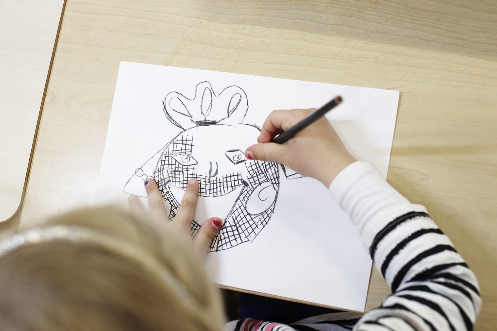 Et barn tegner en tegning av et ansikt. Foto: Øivind Haug