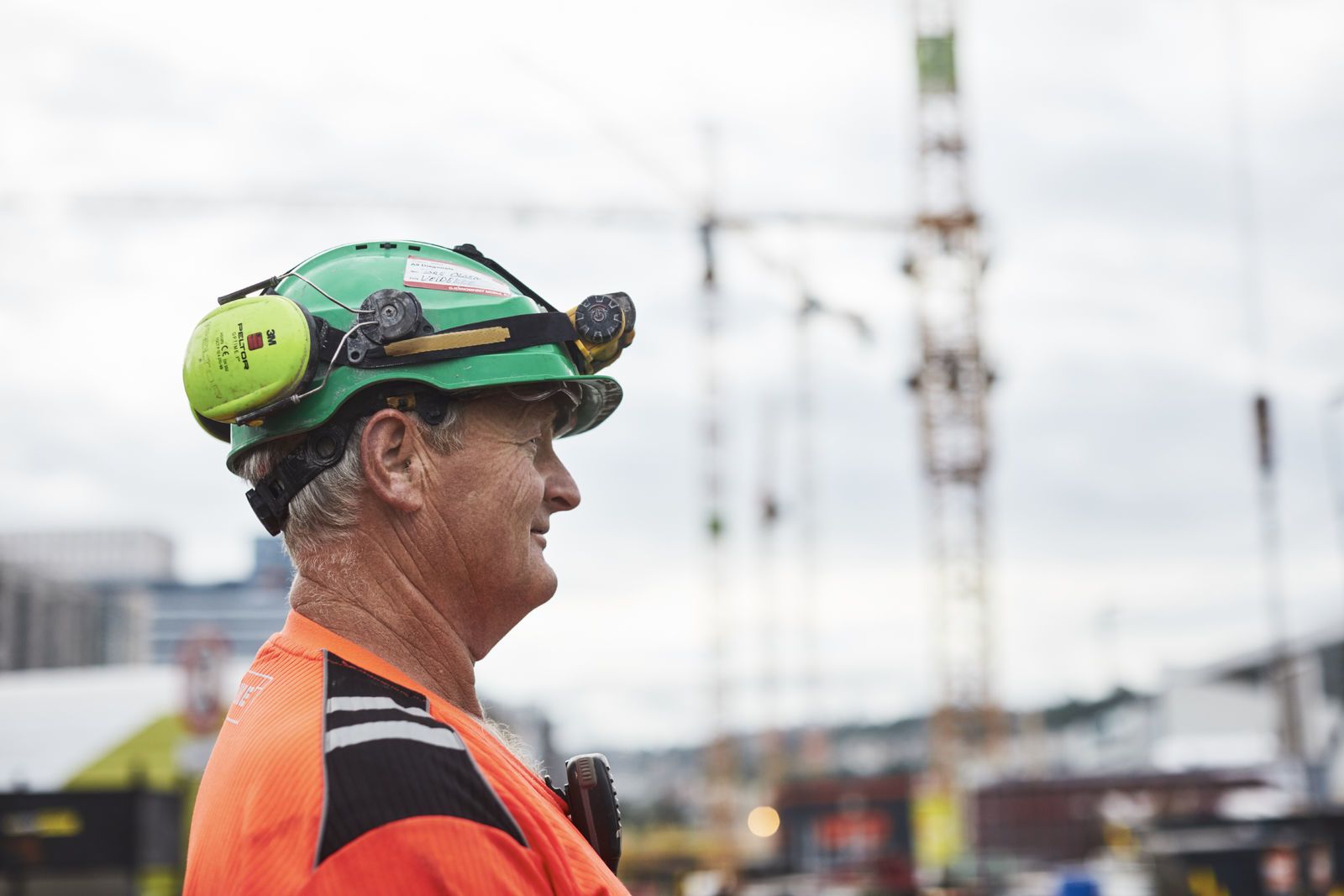 En anleggsarbeider står i profil, i bakgrunnen er det geisekraner. Foto: Øivind Haug