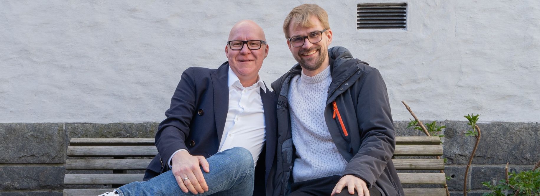 Rune Bakervik og Roger Valhammer smiler på en benk