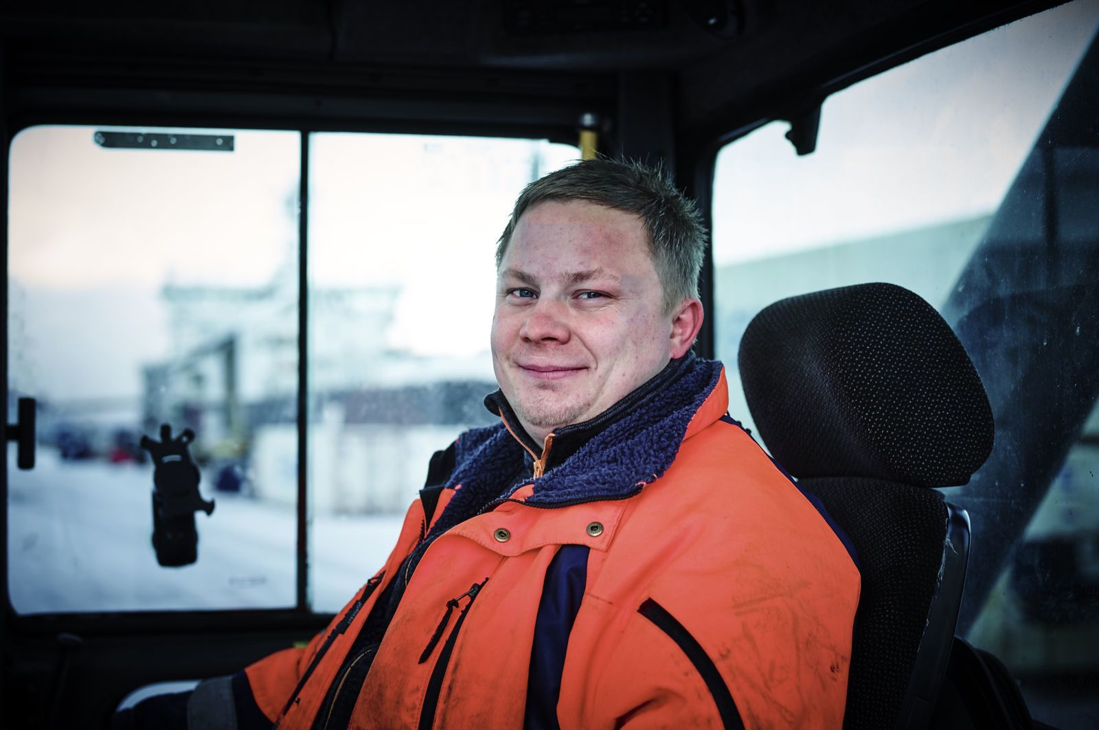 Portrett av en havnearbeider som sitter i førersetet sitt. Foto: Øivind Haug