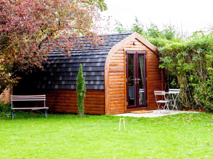 A camping pod situated beside a hedge at Langar Hall.