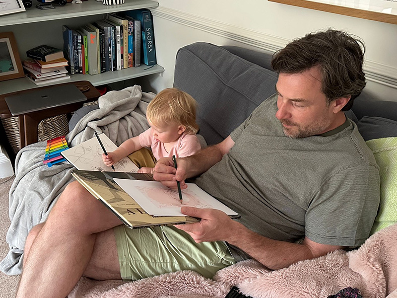 Photograph of illustrator Richard Johnson and his daughter drawing
