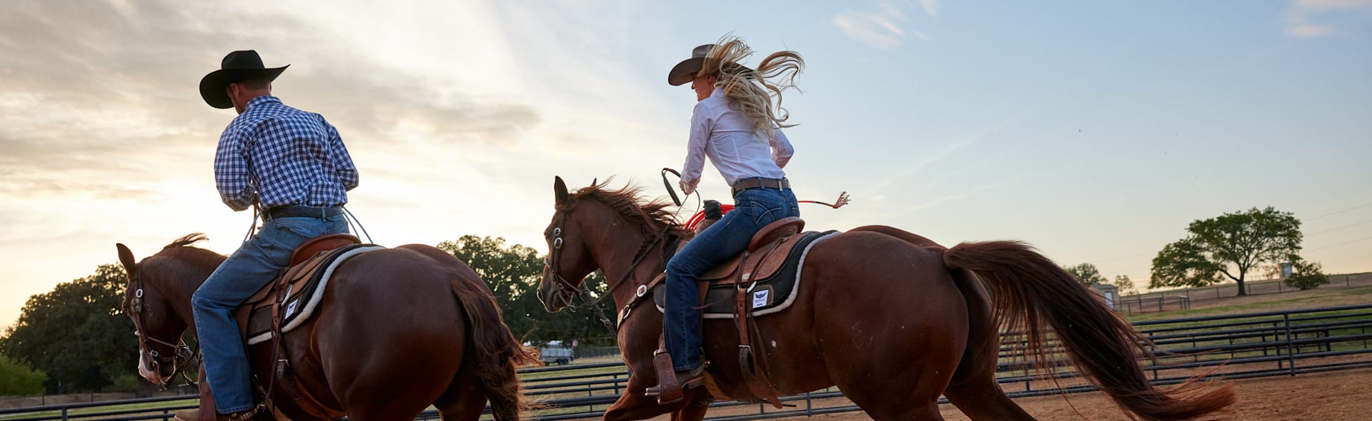 A woman and a man riding horses in a ring.