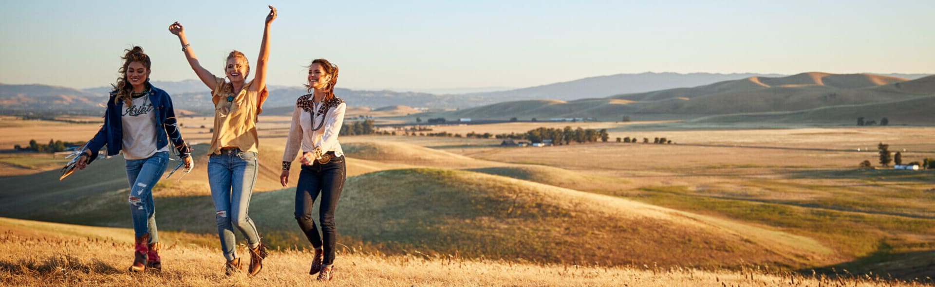 three women walking in hills